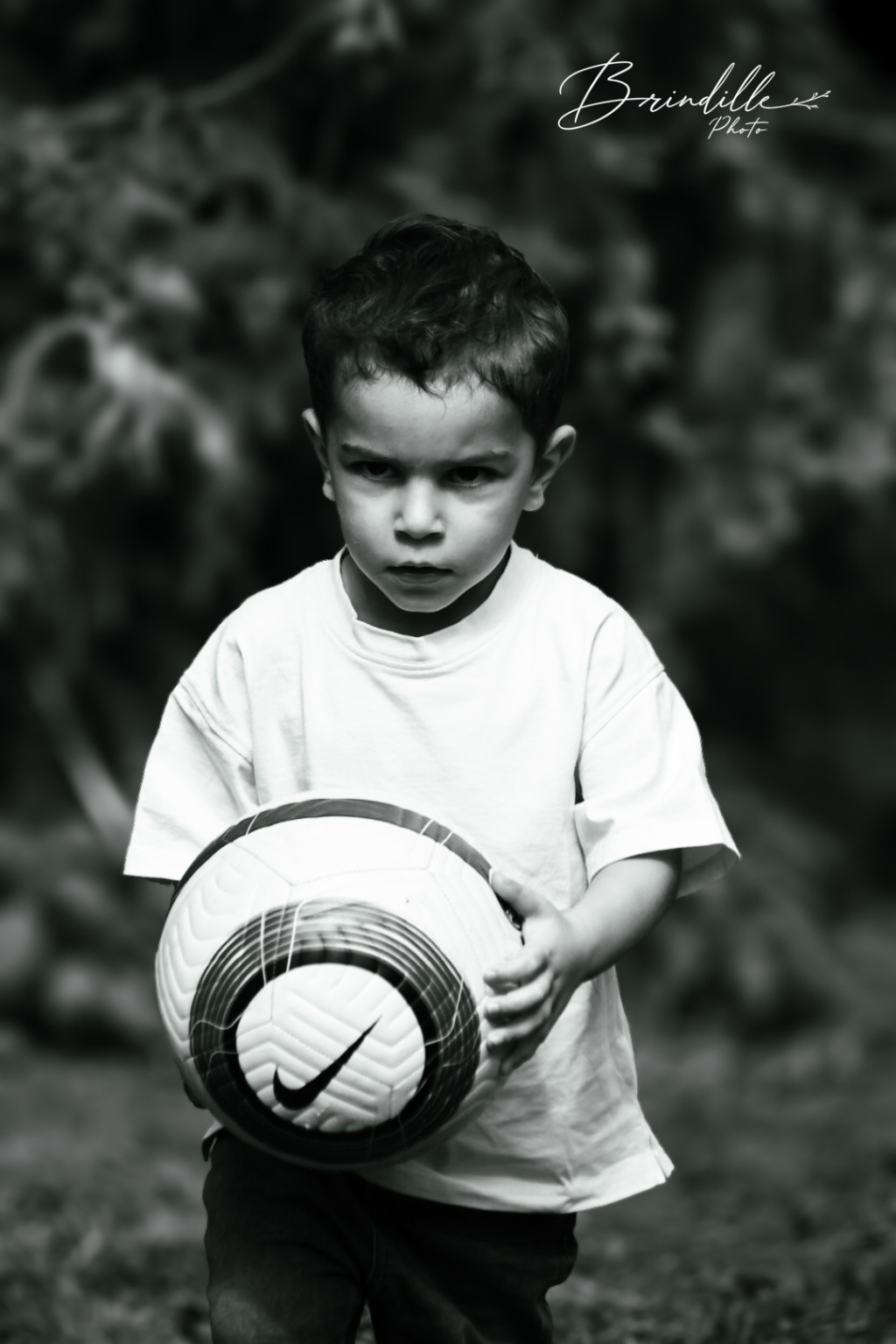 Enfant tenant un ballon, portrait noir et blanc