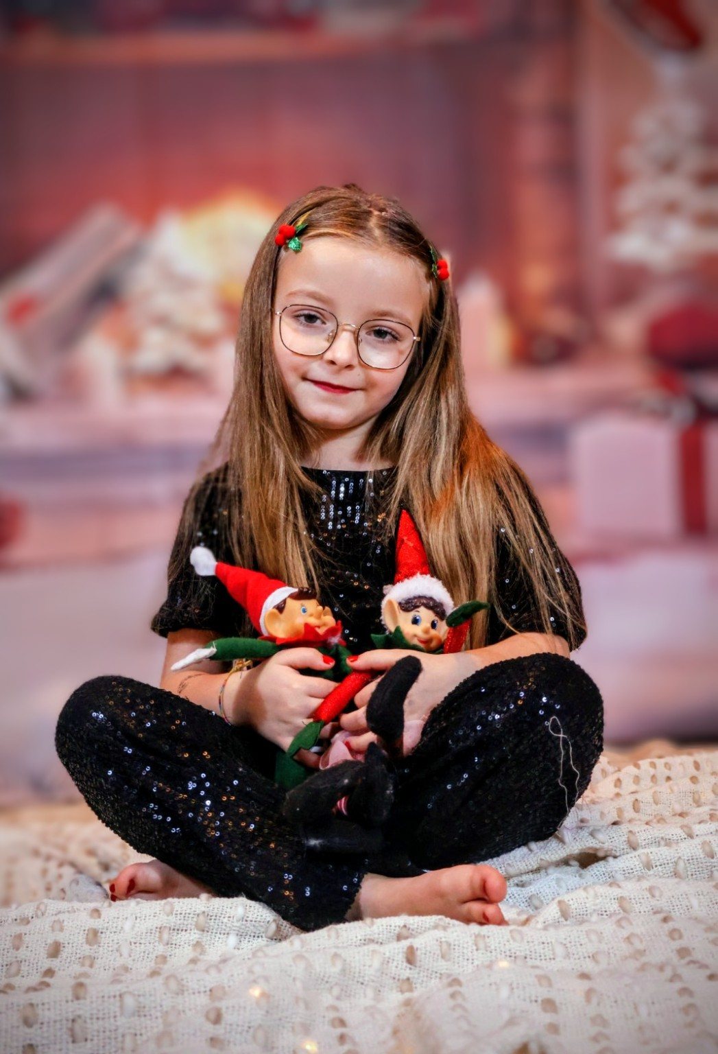 Enfant assise avec deux lutins de Noël